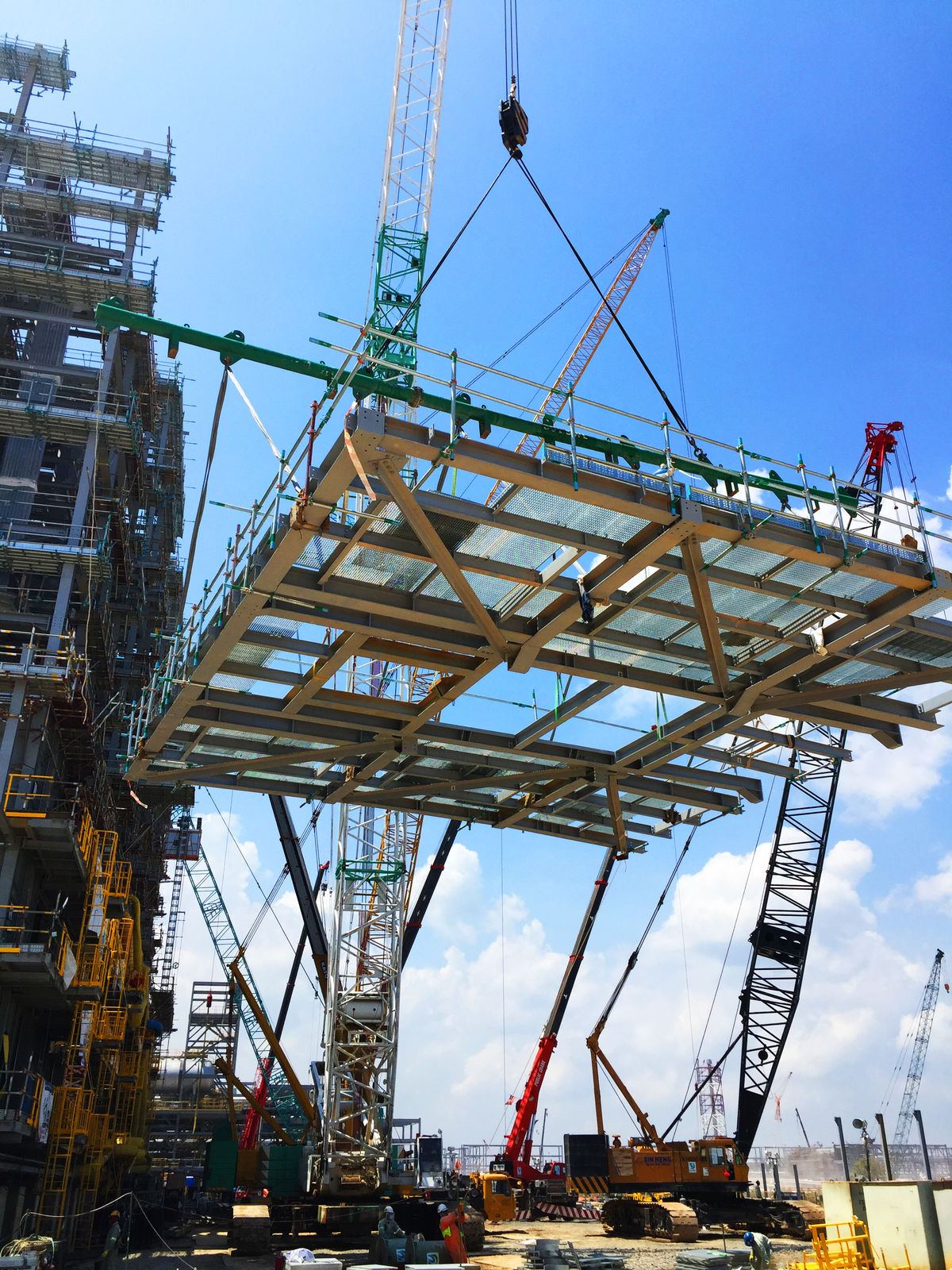 A steel module lifted by crane with a YSSE spreader bar on site