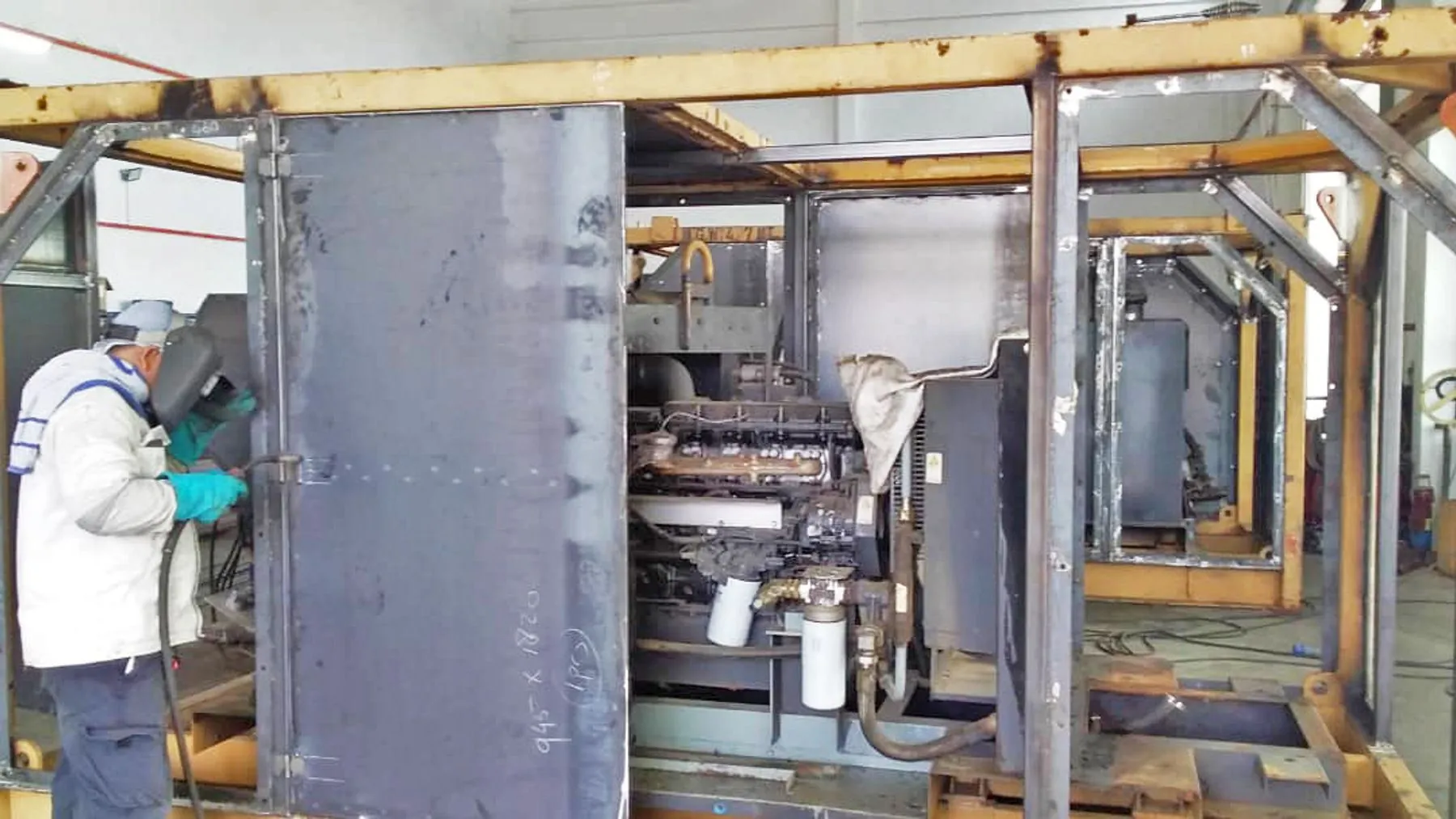Welder working on an offshore machine frame cover in the YSSE workshop