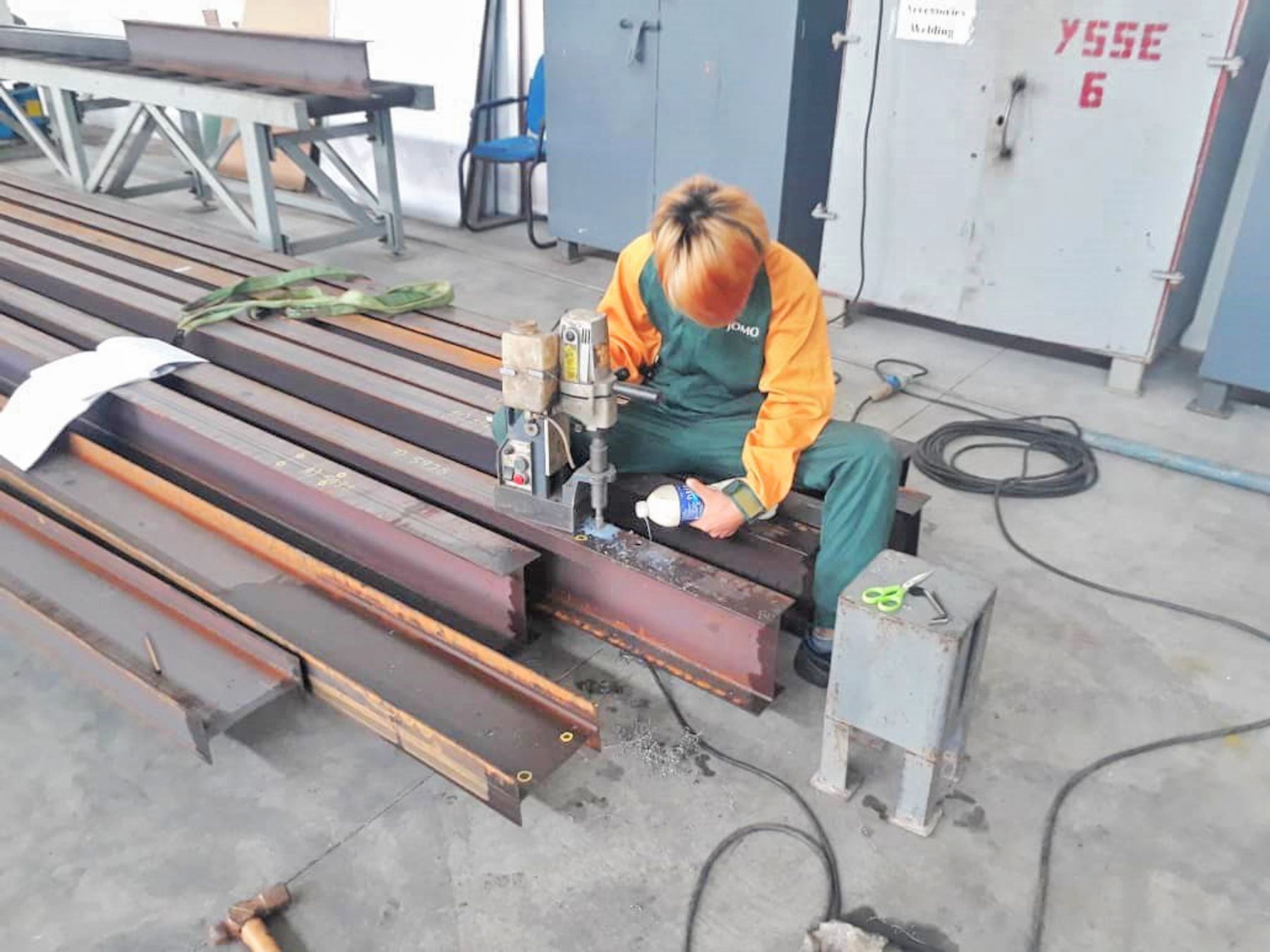 YSSE fabricator drilling steel beams in the workshop